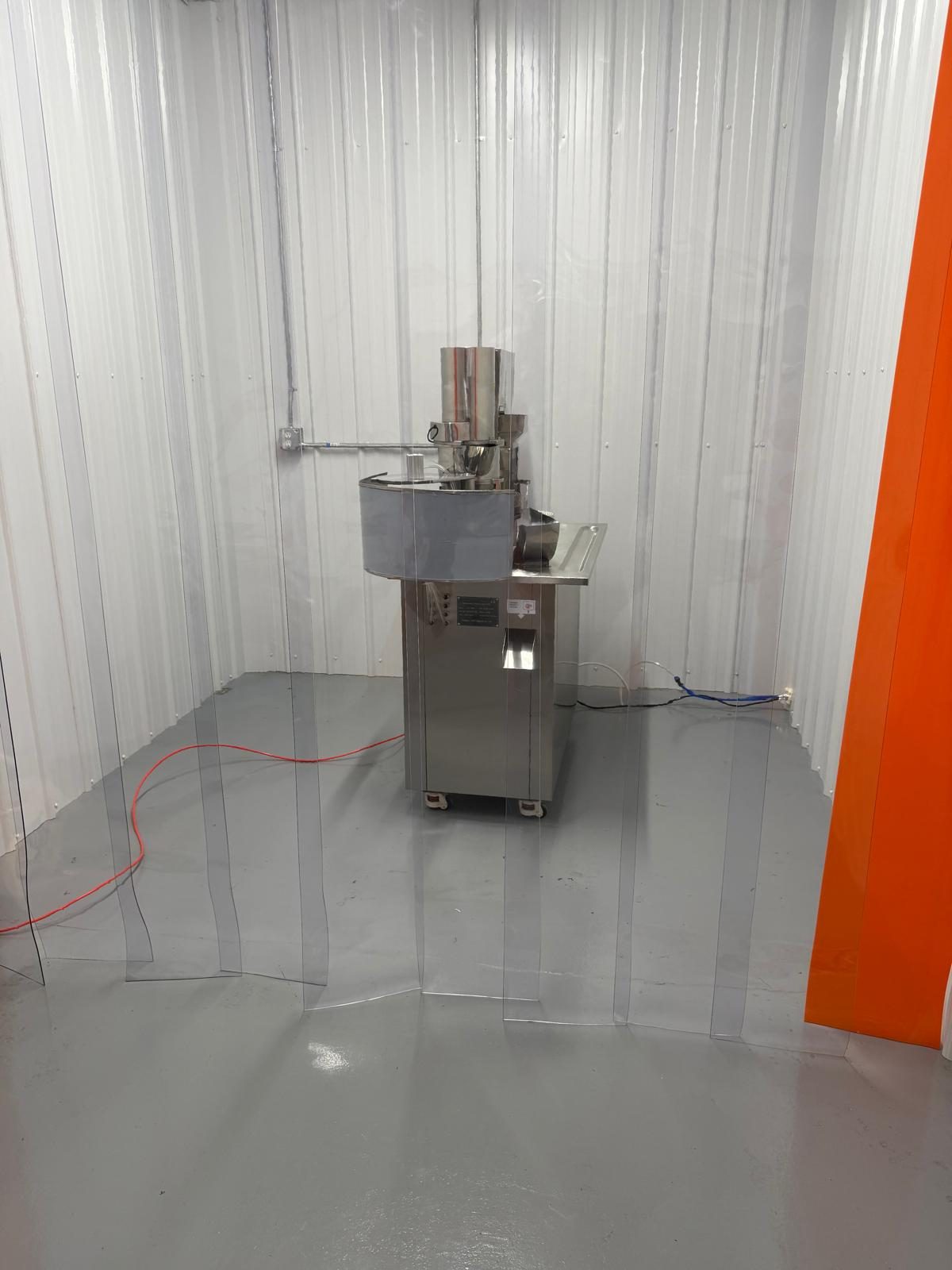 The filling room, the semi-automatic filler in the middle of an otherwise empty white room