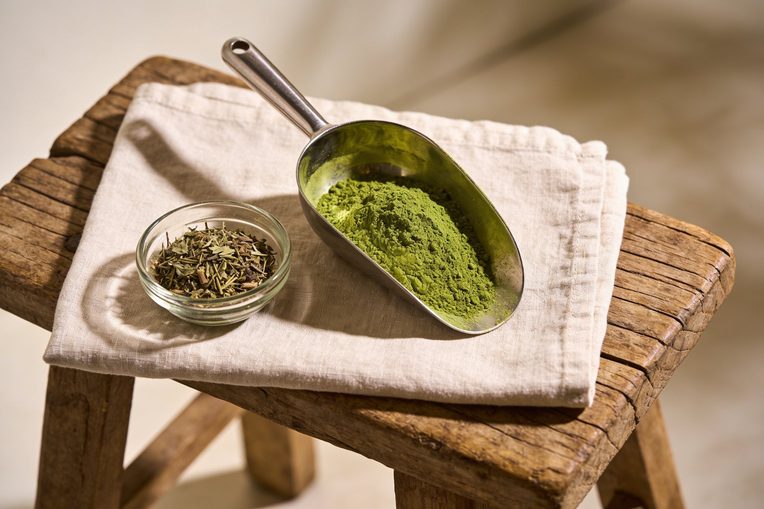 Scoop of botanical powder on a wood bench